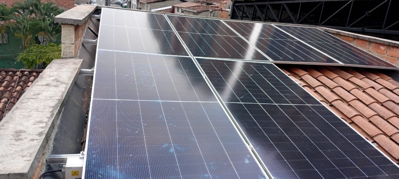 Fila de paneles solares sobre un techo de teja de barro, vista de cerca.